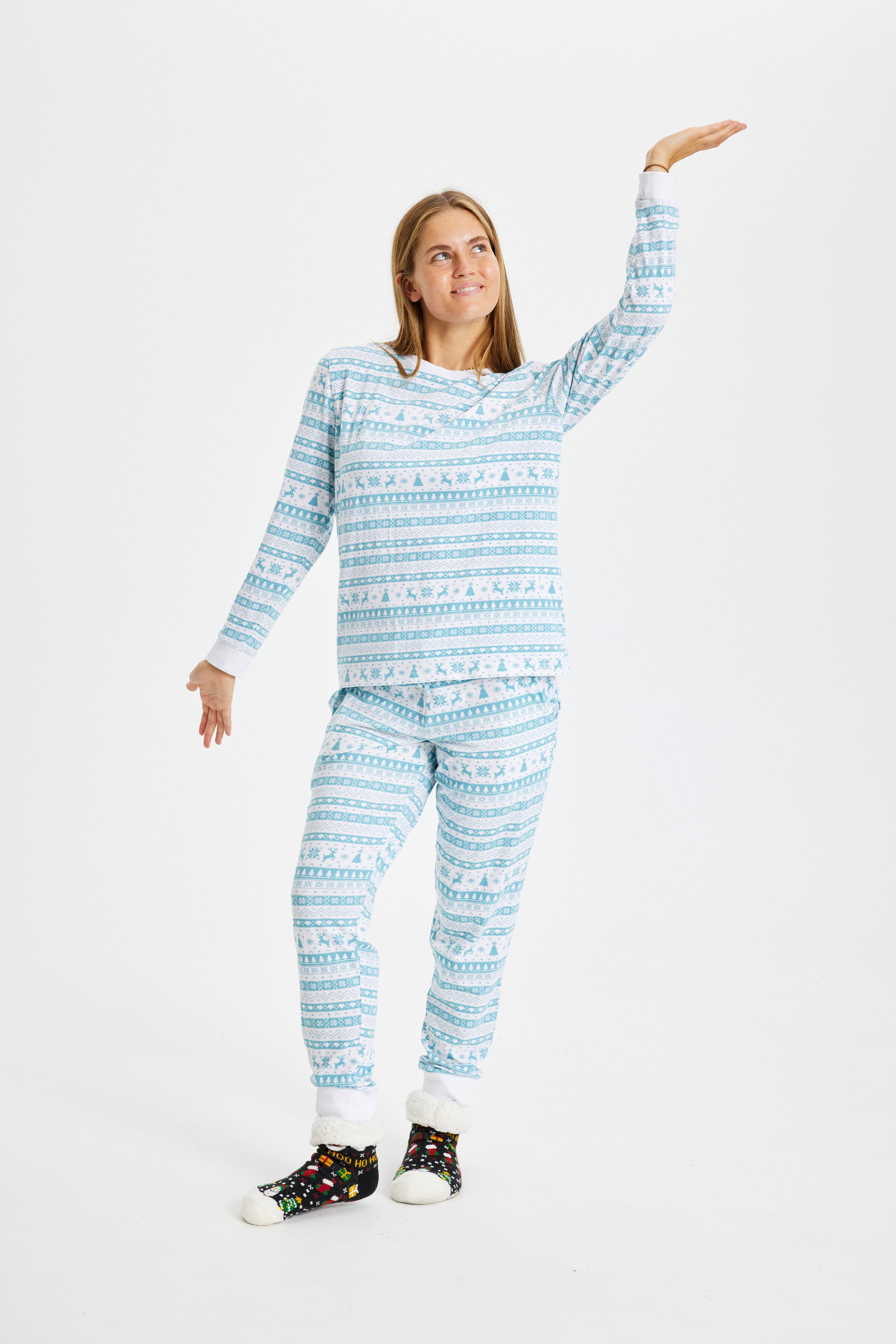 Een vrouw die een lichtblauwe kerstpyjama draagt.